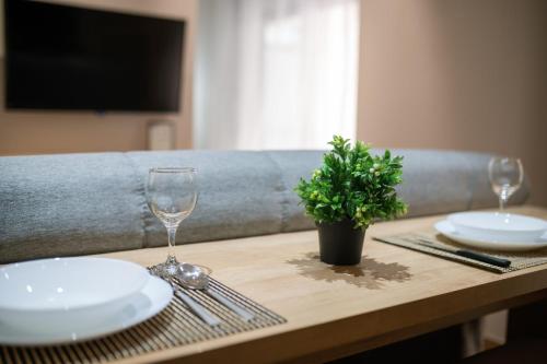a table with two glasses and a potted plant on it at Stamatina's Luxury Apartment (Little Suite) in Alexandroupoli