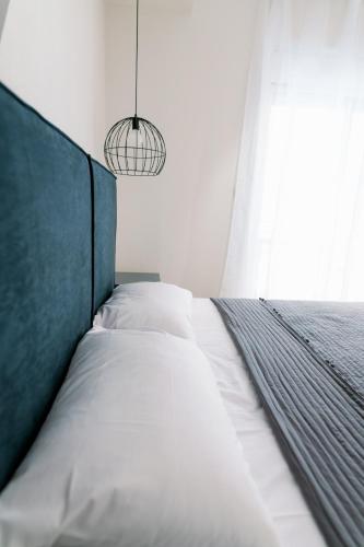 a bedroom with a bed with a green headboard and a window at Stamatina's Luxury Apartment (Little Suite) in Alexandroupoli