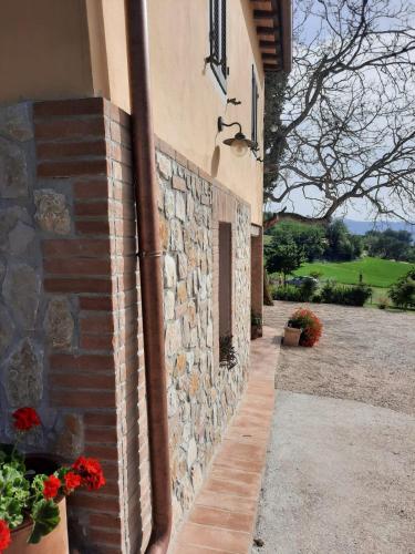 a brick building with a stone wall and flowers at Agriturismo Il Truffarello TODI in Todi