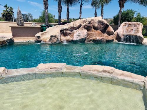 a swimming pool with a waterfall in a resort at HighEnd Rooms in Mansion in Riverside