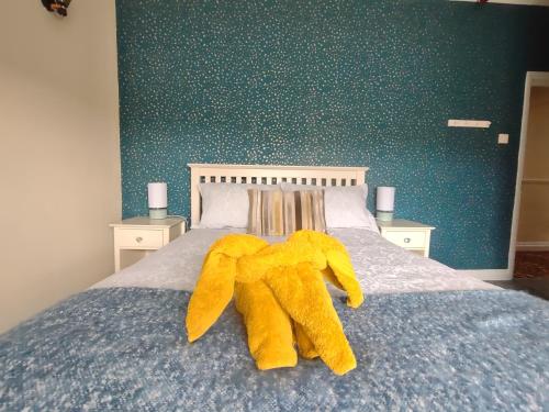 a yellow stuffed animal laying on a bed at The Shoulder at Hardstoft in Hardstoft
