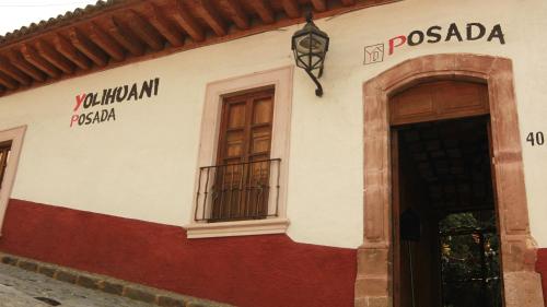 a building with two windows and a door at Posada Yolihuani in Pátzcuaro