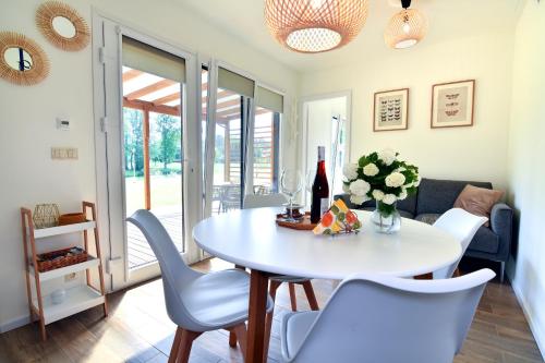 une salle à manger avec une table et des chaises blanches dans l'établissement Cisza & Spokój, à Człopa