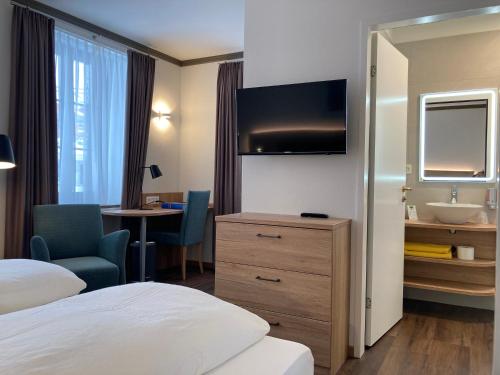 a hotel room with a bedroom with a bed and a sink at Hotel Blattnerhof in Blatten bei Naters