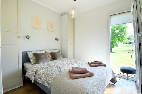 a bedroom with a bed with two towels on it at Cisza & Spokój - Jeziora, Lasy i Drawieński Park in Człopa