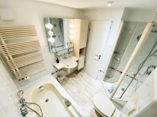 a bathroom with a tub and a toilet and a sink at Blankensteiner Seeblick in Hattingen