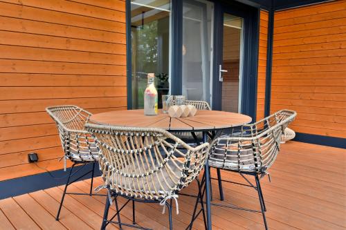 a wooden table with chairs and a bottle of wine at Cisza & Spokój - Jeziora, Lasy i Drawieński Park in Człopa