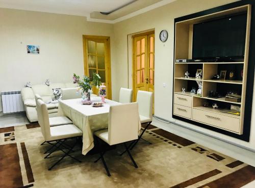 a living room with a white table and a television at Ekas Rosengarten in Gori