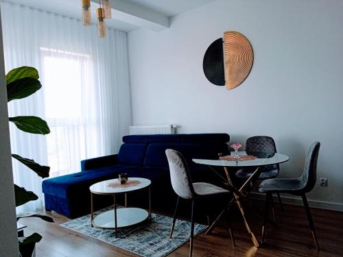 a living room with a blue couch and two tables at Apartament z widokiem Łańcut in Łańcut