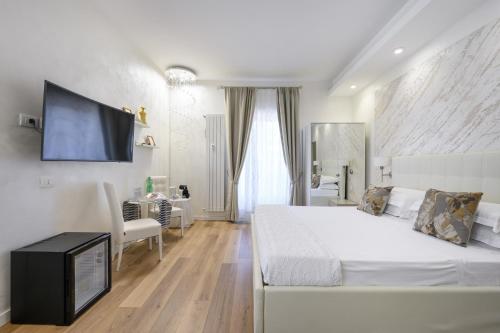 een slaapkamer met een wit bed en een tv aan de muur bij La Meraviglia- San Pietro - Vatican Area in Rome