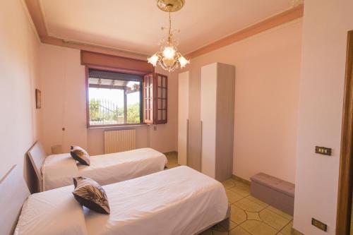 a room with two beds and a chandelier at Casa Vacanze Lavinia in Castro di Lecce