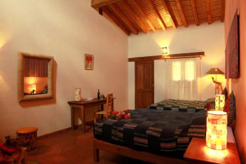 a bedroom with a bed and a table and a mirror at Posada Yolihuani in Pátzcuaro
