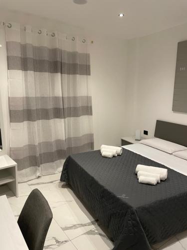 una camera da letto con un letto e due asciugamani di Casa vacanze donna Pina a Palermo