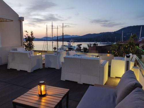 a balcony with white furniture and a view of a boat at The Manessi City Boutique Hotel in Poros