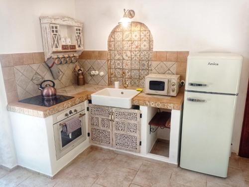 a small kitchen with a refrigerator and a sink at Bungalov Trapani in Růžová