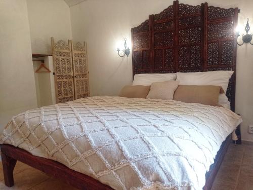 a bedroom with a large bed with a wooden headboard at Bungalov Trapani in Růžová