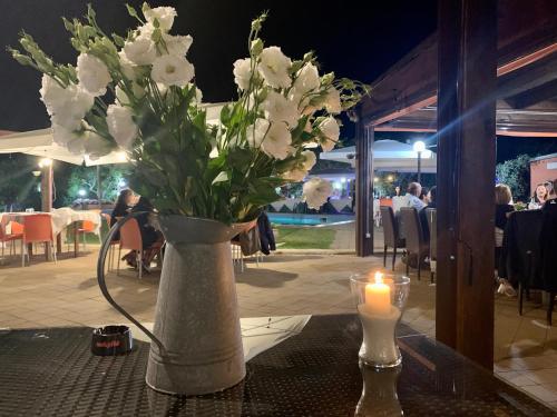 a vase of flowers on a table with a candle at Agriturismo Villa Pina in Lizzanello