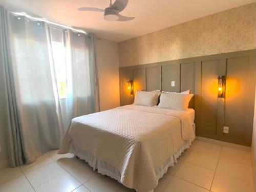 ein Schlafzimmer mit einem weißen Bett und einem Fenster in der Unterkunft Hotel APART Zuccolotto 202 in Aracruz