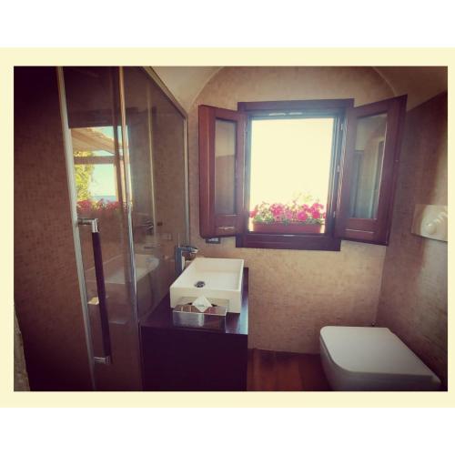 a bathroom with a sink and a toilet and a window at Birbiciù mare in Pantelleria