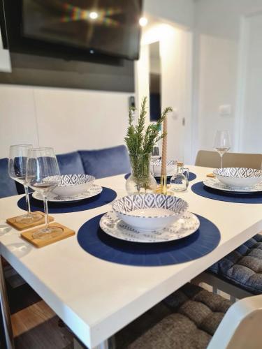 a table with plates and wine glasses on it at Rosmarin&Olive Premium Mobile Homes in Selce