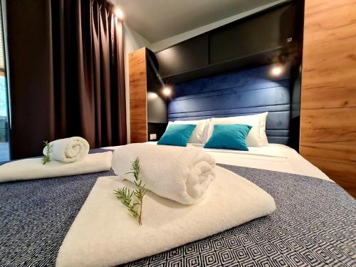 a bedroom with two beds with towels on them at Rosmarin&Olive Premium Mobile Homes in Selce