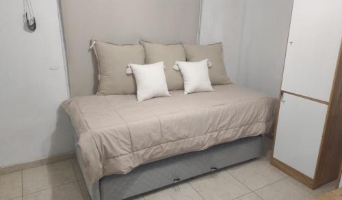 a small bed with two pillows on top of it at Departamento Alquiler Costa Azul para 5 personas in Costa Azul