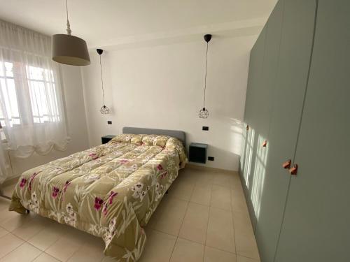 1 dormitorio con 1 cama en una habitación blanca en Appartamento L'Olivo, en Latina