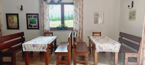 a dining room with two tables and chairs and a window at Dom pod Dziką Gruszą in Piecki
