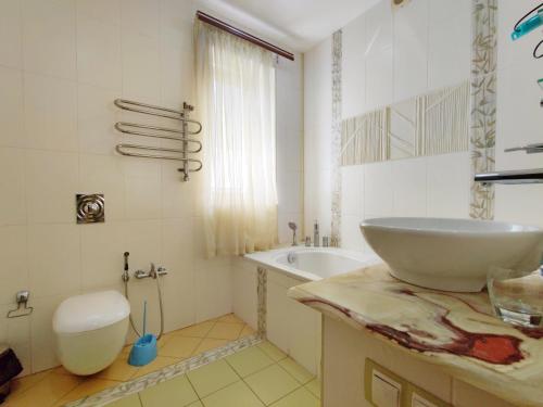 a bathroom with a sink and a tub and a toilet at Приватний котедж з Басейном біля моря Совіньон Одеса in Odesa