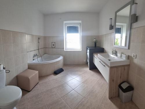 a bathroom with a tub and a sink and a toilet at Dwupokojowy Apartament z widokiem na kanał Augustowski in Augustów