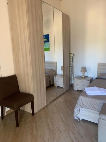 a bedroom with a mirror and a chair and a bed at Agriturismo Villa Pina in Lizzanello