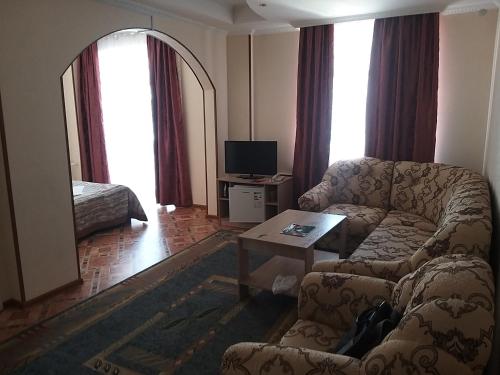 a living room with a couch and a table at Гостиница Караганда in Karagandy
