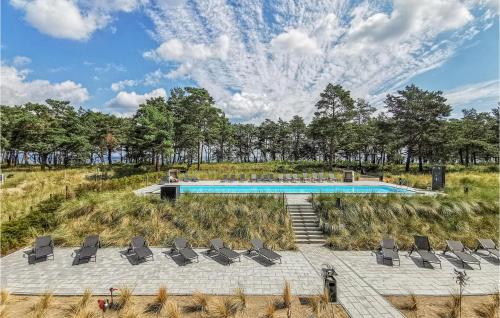 a swimming pool in a field with chairs at Prora Solitaire Panorama 05 in Binz