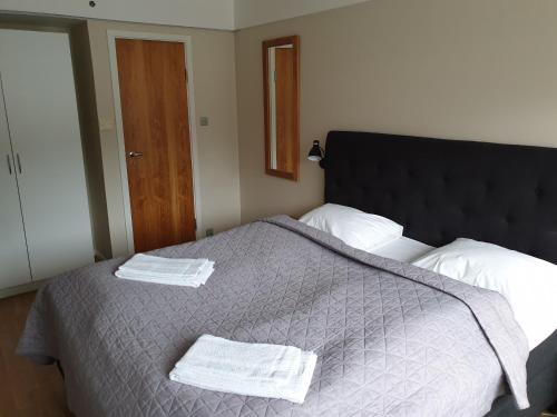 a bedroom with a large bed with two towels on it at Bremanger Fjord Hotell in Svelgen
