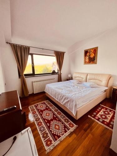 a bedroom with a bed and a large window at Belvedere Resort Moieciu in Moieciu de Jos