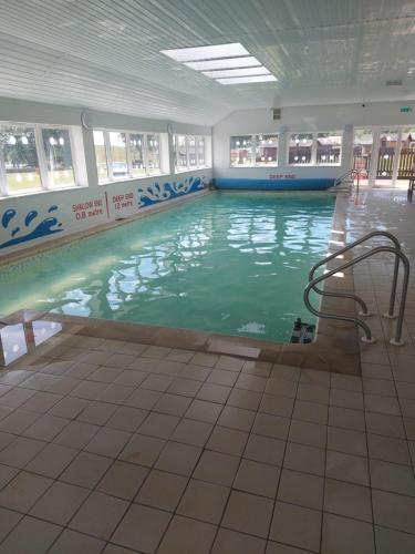 a swimming pool in a building with green water at 57 Peaceful Corner Caravan in Balminnoch