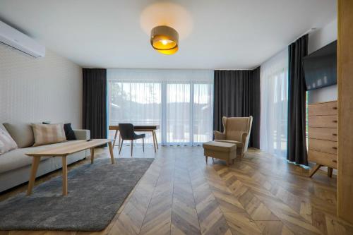 a living room with a couch and a table and chairs at Hotel Łaziska in Czchów