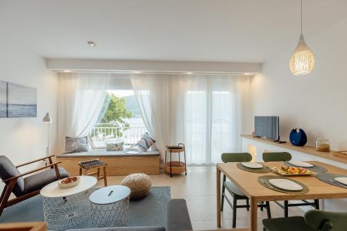 Una cocina y una sala de estar con mesa y sillas. en Tamaris beach apartment, en Herceg-Novi