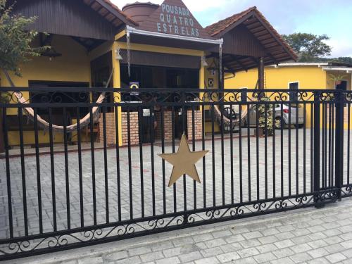 a black fence with a star on it in front of a store at Pousada Quatro Estrelas in Penha