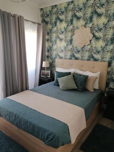 a bedroom with a bed with a blue comforter at The Violet House in Costa Nova