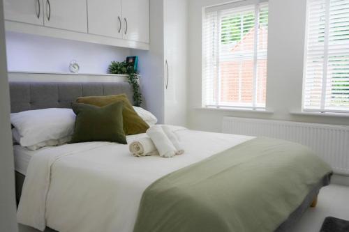una camera da letto con un grande letto bianco con asciugamani di 3 BED new build home with FREE parking BHX NEC HS2 CONTRACTORS FAMILIES a Solihull
