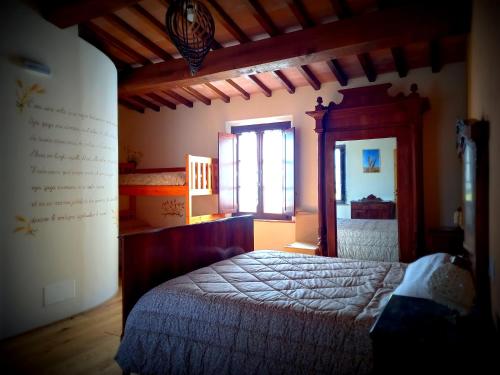 ein Schlafzimmer mit einem großen Bett und einem Fenster in der Unterkunft Agriturismo Podere Padolecchie - Azienda Agricola Passerini in Torrita di Siena