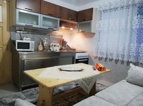 Una pequeña cocina con una mesa y un microondas. en ROMANCE Apartments, en Tirana