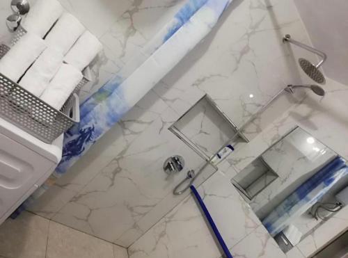 La salle de bains est pourvue d'une douche en marbre et d'un miroir. dans l'établissement ROMANCE Apartments, à Tirana