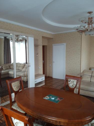 a living room with a table and chairs and a couch at Гостиница Караганда in Karagandy
