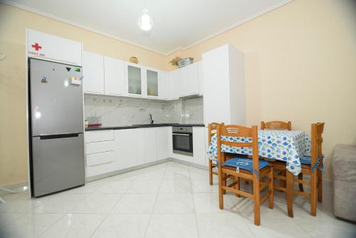 a kitchen with a refrigerator and a table and chairs at DANTE APARTAMENT in Vlorë