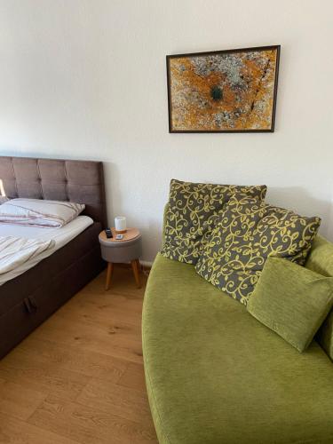 una camera da letto con un divano verde e un dipinto sul muro di Schöne Ferienwohnung mit kostenlosem Parkplatz a Cottbus