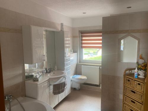 een witte badkamer met een wastafel en een toilet bij Ferienwohnung „Thea“ in Bad Lausick