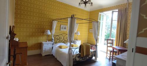 a bedroom with a bed and a yellow wall at Chambres d'Hôtes-Château Constant in Bessines-sur-Gartempe