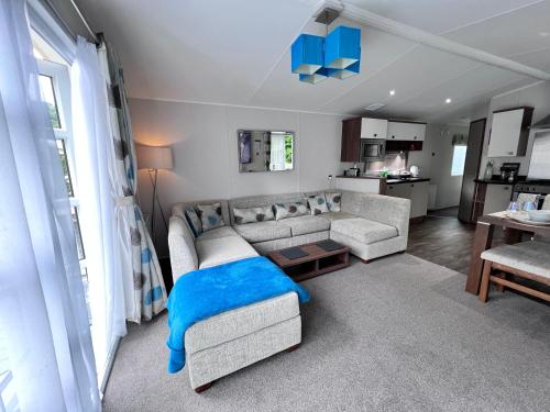 a living room with a couch and a table at Snowdonia Holidays Caravan Hire - Aberdunant Park - 34 The Green in Prenteg